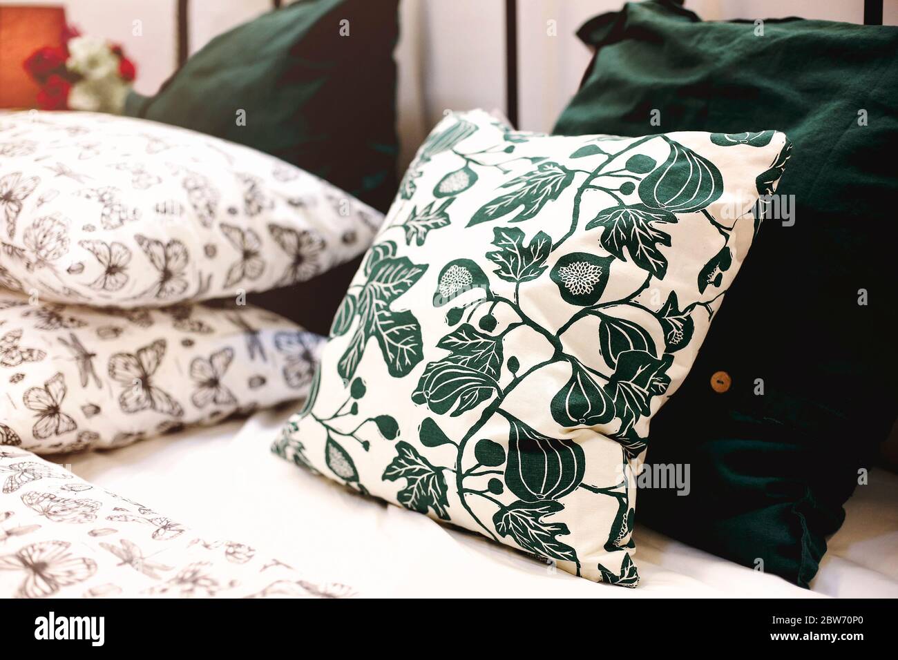 Set of various pillows with different natural ornaments and colors arranged on bed in modern apartment Stock Photo