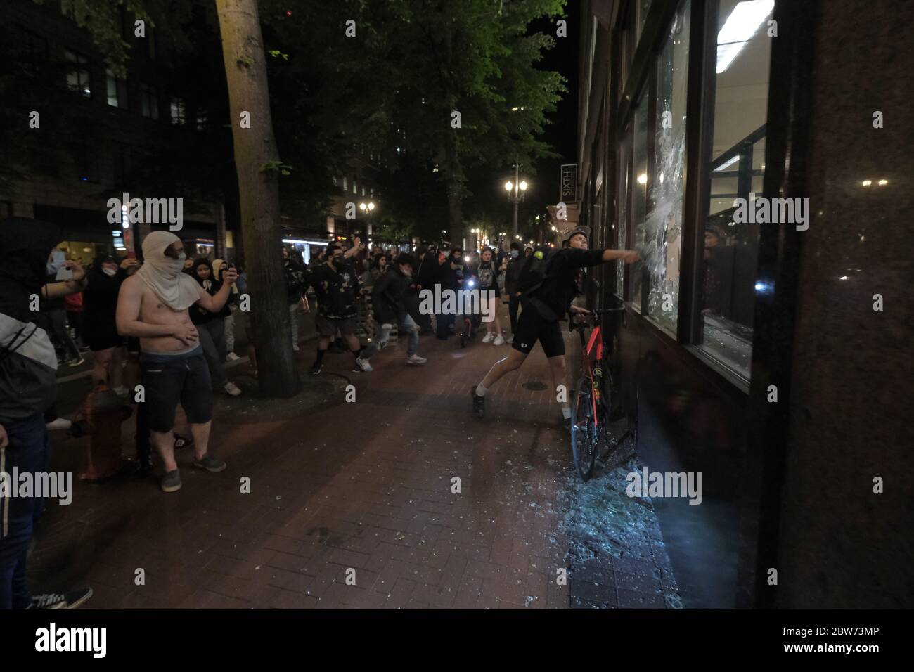 Portland, USA. 29th May, 2020. Protesters walk by graffiti on the Louis  Vuitton store in Portland, Ore., on May 29, 2020. (Photo by Alex Milan  Tracy/Sipa USA) Credit: Sipa USA/Alamy Live News