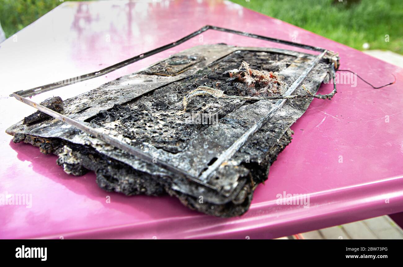 Broken laptop computer spoiled by flame of hot fire. Destroyed notebook