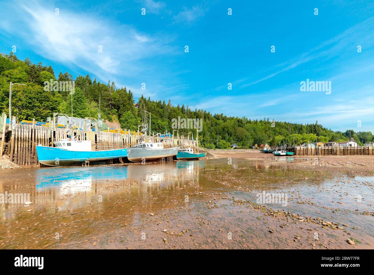St. Martins, NB, Canada August 3, 2019 Fishing boats rest in the mud at low tide. The Bay of St. Martins, NB, Canada August 3, 2019 Fishing boats rest in the mud at low tide. The Bay of
