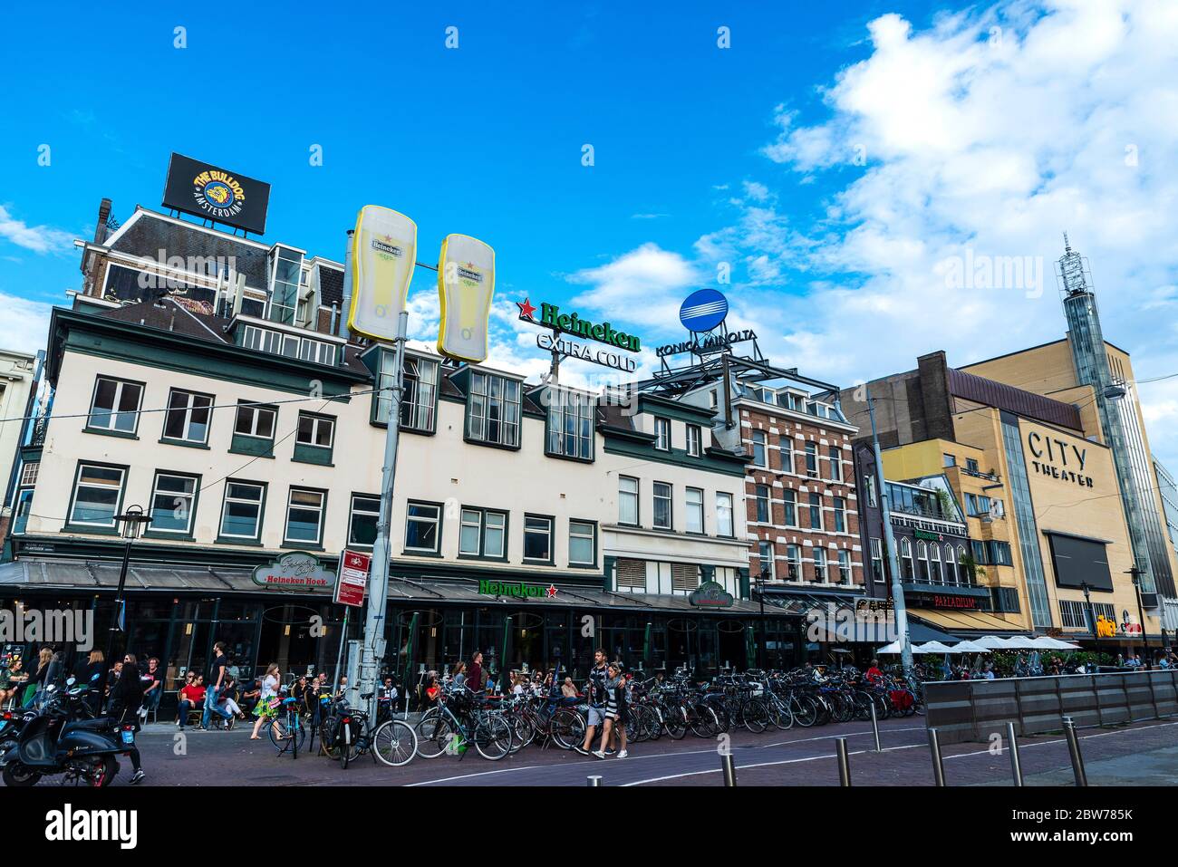 Amsterdam, Netherlands - September 9, 2018: Street with people on the bar terraces and Heineken sign in Amsterdam, Netherlands Stock Photo