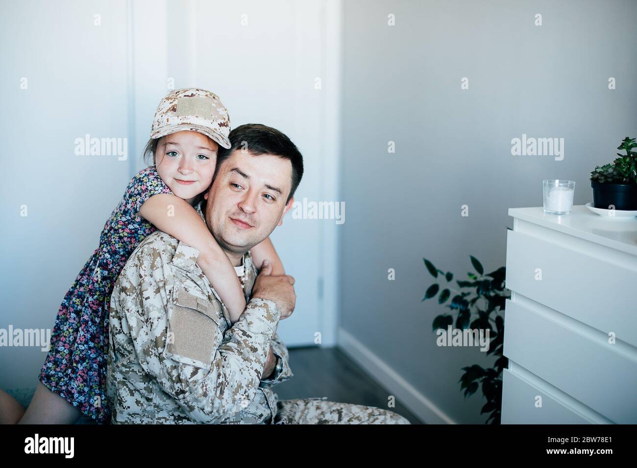 Military man father hugs daughter. Portrait of happy american family. Stock Photo