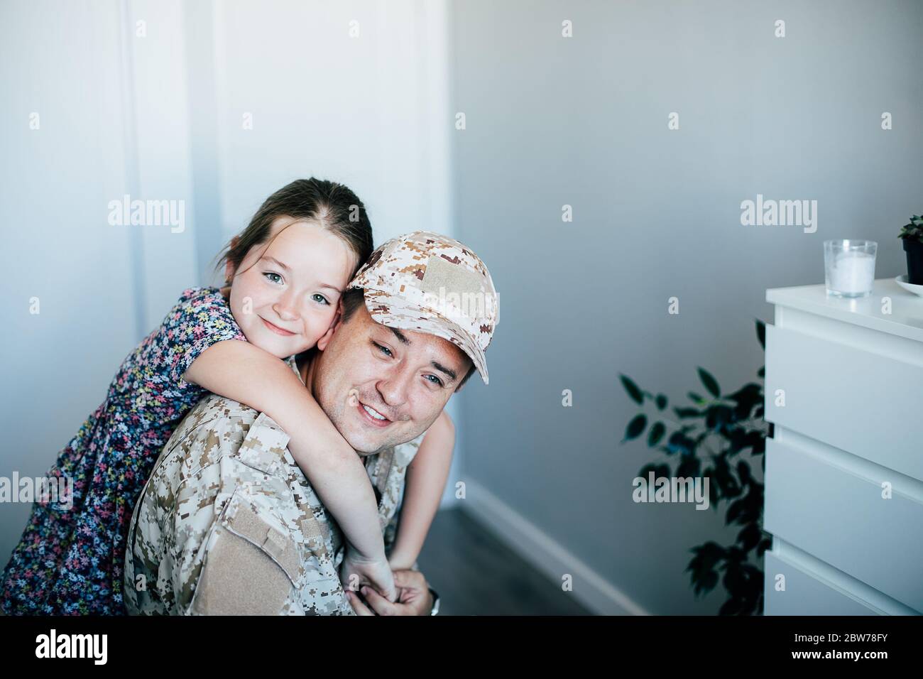Military man father hugs daughter. Portrait of happy american family. Stock Photo