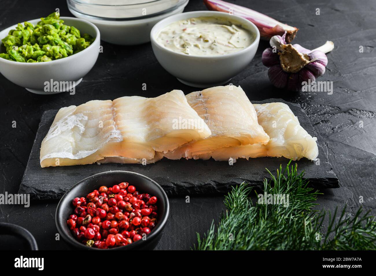 Organic fish and chips ingredients raw cod fillets on stone slate