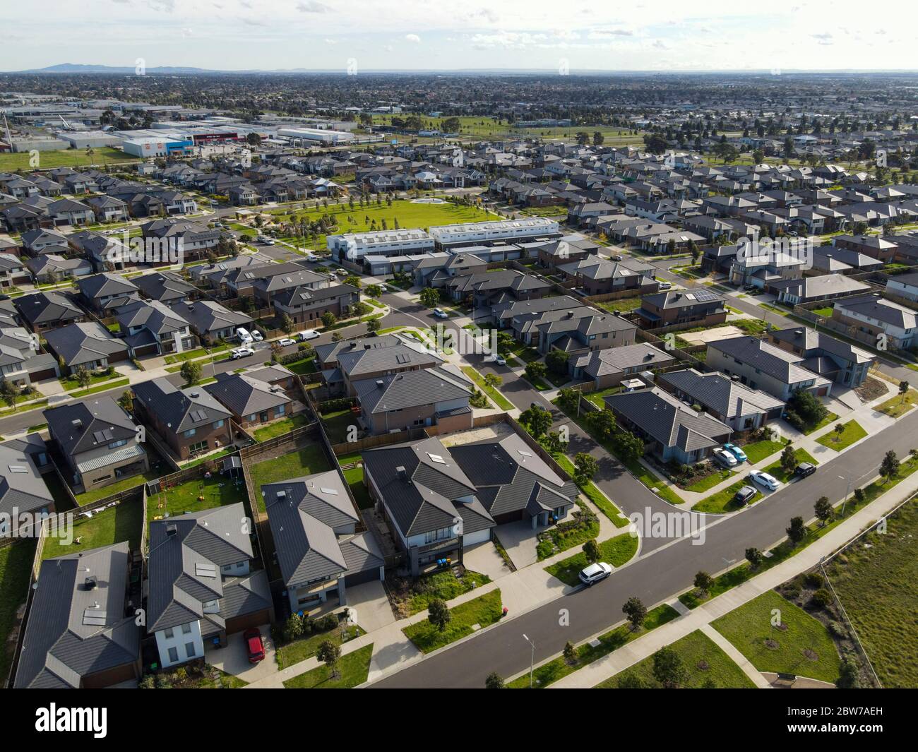 Aerial view of new homes built in new suburbs urban sprawl government rebates on sunny day and parkland industry mountain Melbourne Victoria Australia Stock Photo