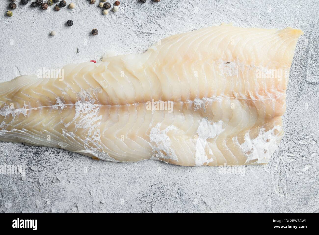 Cod fillets on a grey concrete background for the preparation of a ...