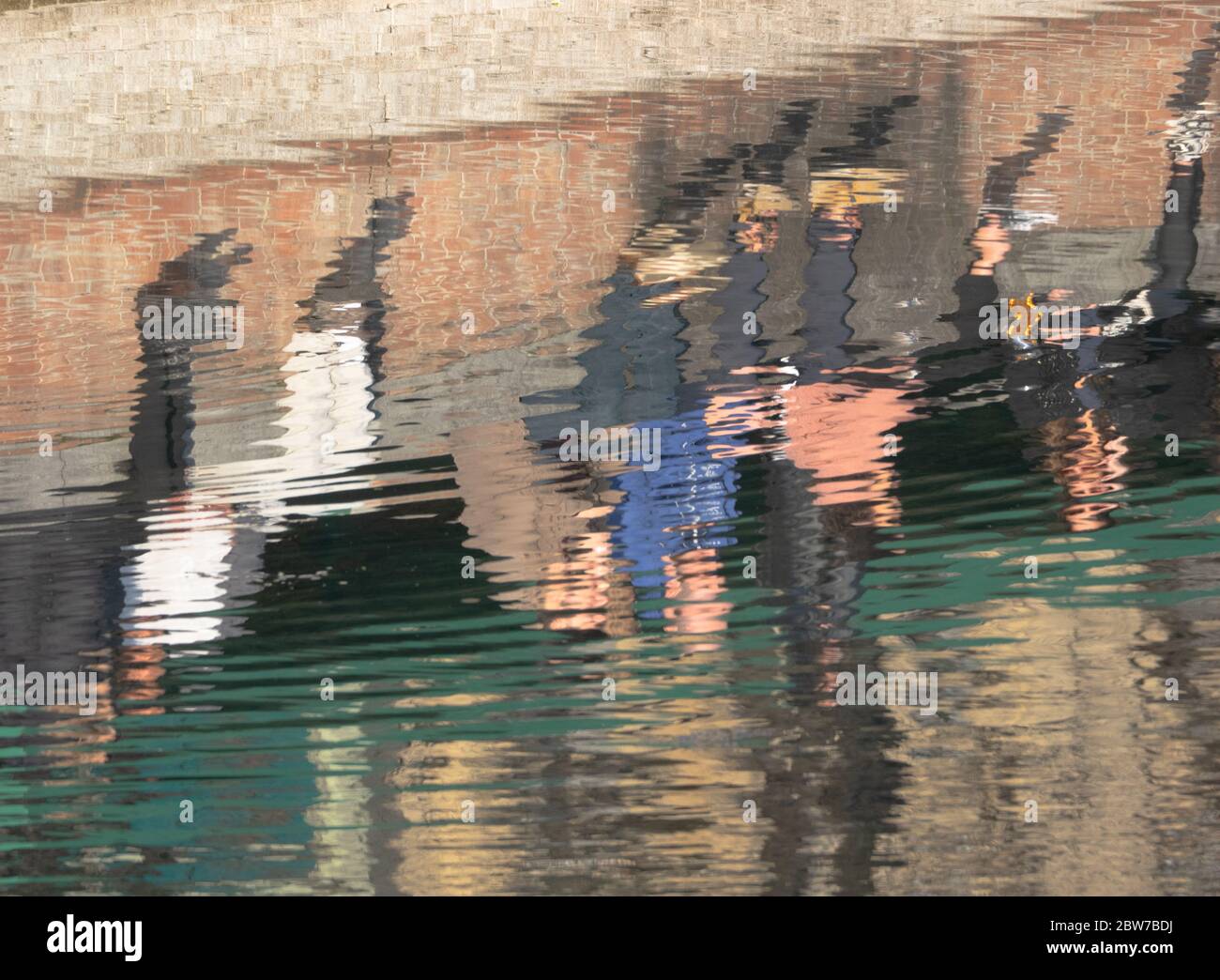 people sitting in the sun to tan reflected in a stream Stock Photo