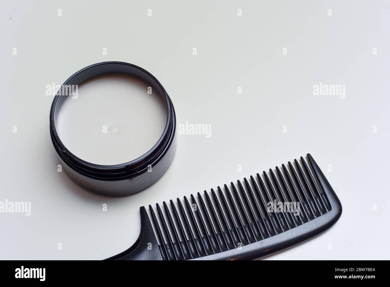 Men's hair product paste with black comb isolated on white background Stock Photo
