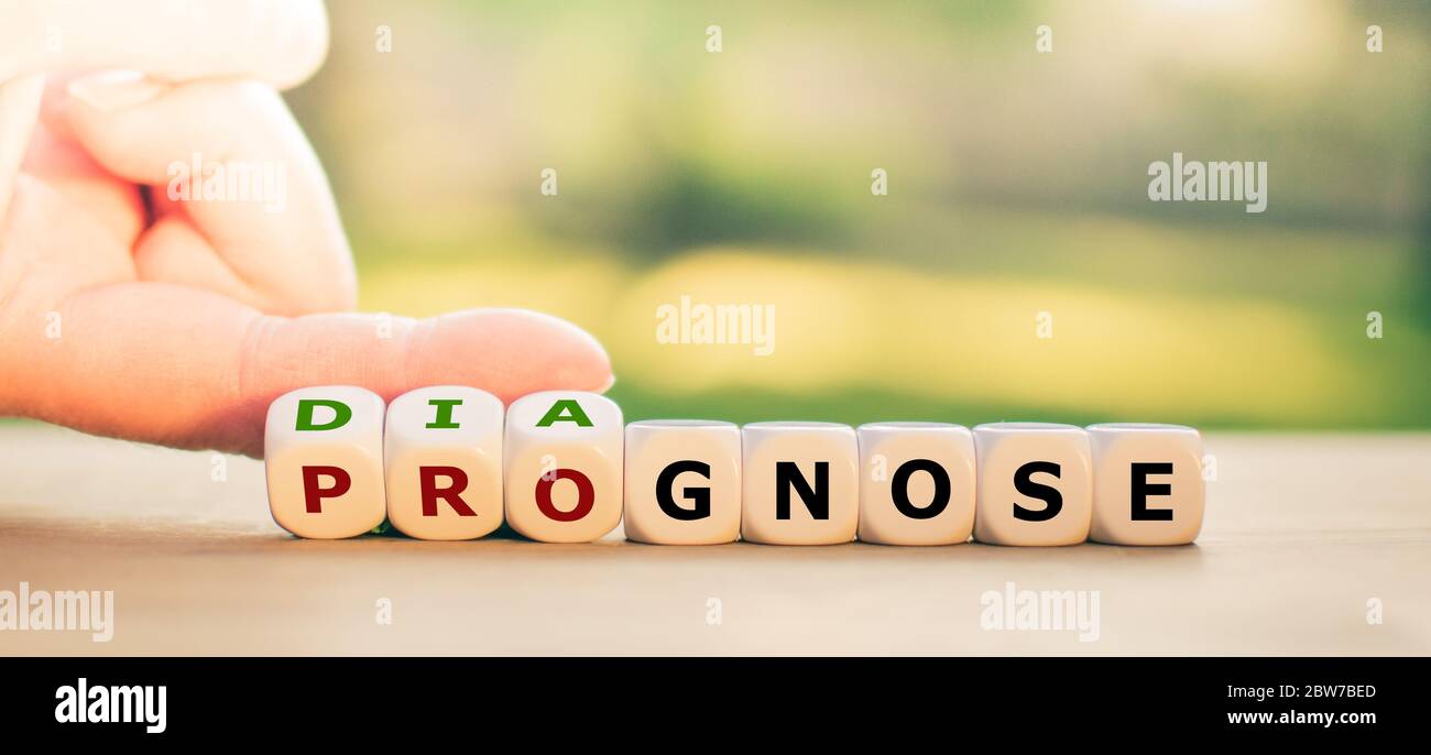 Hand turns dice and changes the word 'prognose' to 'diagnose'. Stock Photo