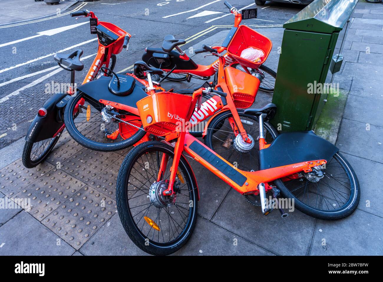 Jump Uber Hire bikes lie in a jumble on the pavement after falling over or being blown over by winds. Stock Photo