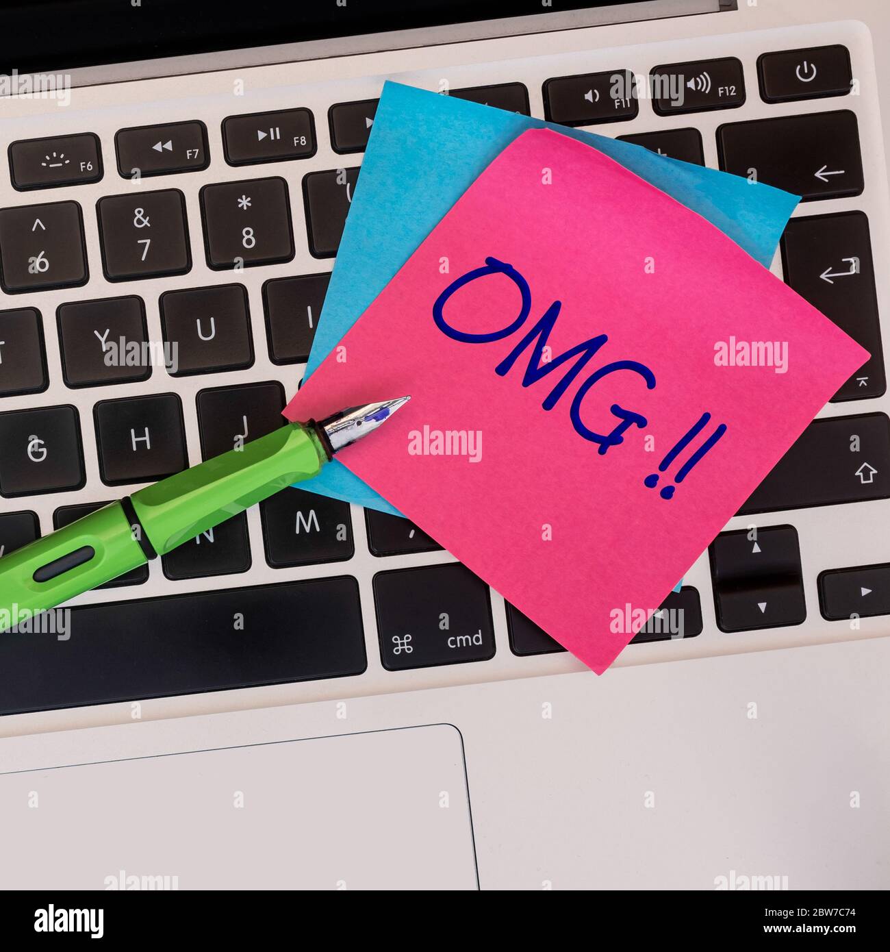 Sticky note on keyboard with text OMG. Conceptual. Stock Photo