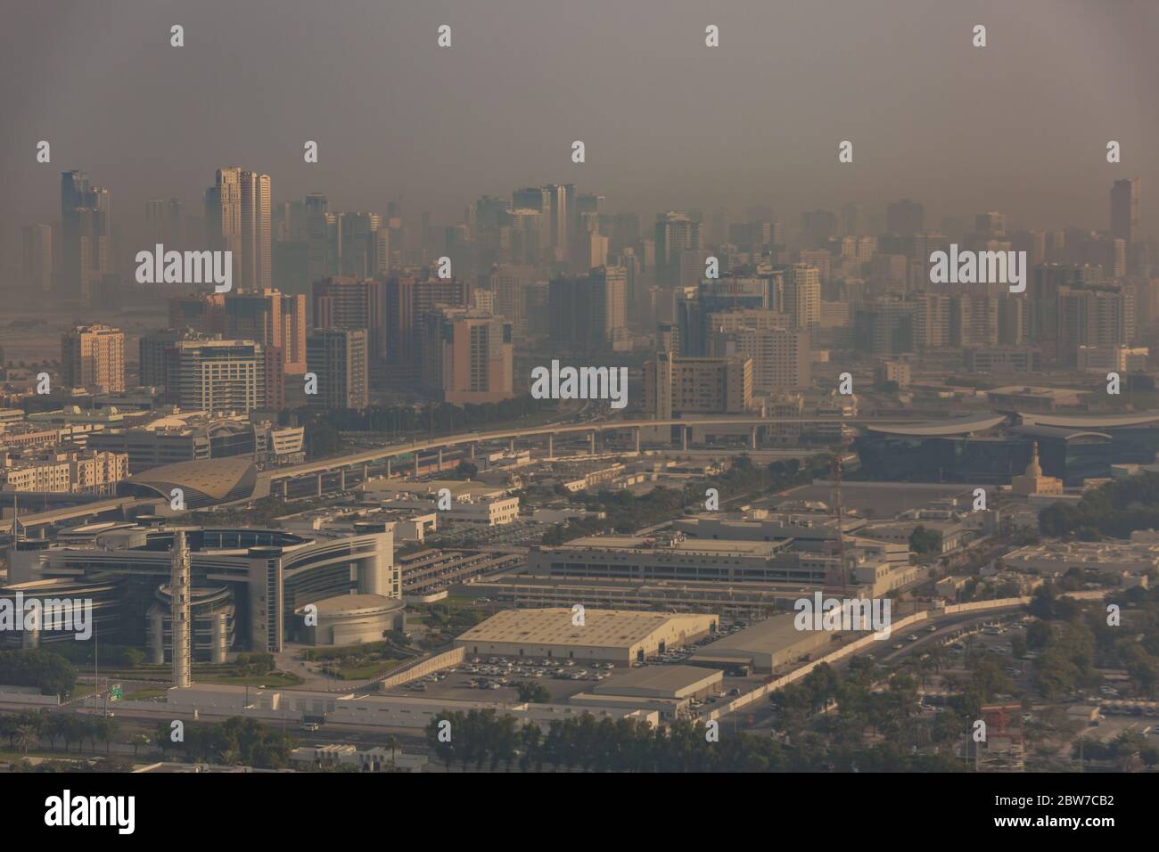 DUBAI, UAE - APRIL 29: Aerial view of Downtown Dubai and skyscrapers  during morning sandstorm. Highway and trainline, soft light over the sand Stock Photo