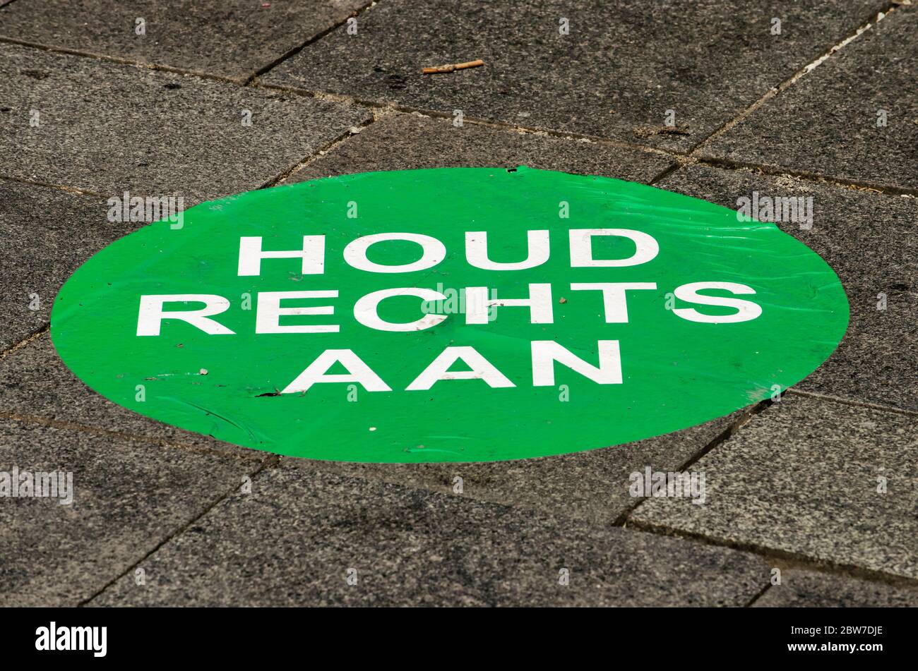 Rotterdam, The Netherlands, May 17, 2020: Large green sticker on pavement in Lijnbaan shopping street asking pedestrians to keep right to prevent spre Stock Photo