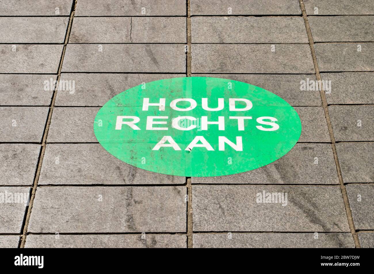 Rotterdam, The Netherlands, May 17, 2020: pavement tiles at Lijnbaan shopping street with large sticker calling for pepole to keep right to prevent sp Stock Photo