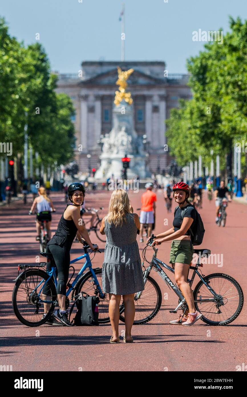 London, UK. 30th May, 2020. Geting others to take photos despite the contamination risk - Enjoying cycling on The Mall as the sun comes out again. The 'lockdown' continues for the Coronavirus (Covid 19) outbreak in London. Credit: Guy Bell/Alamy Live News Stock Photo