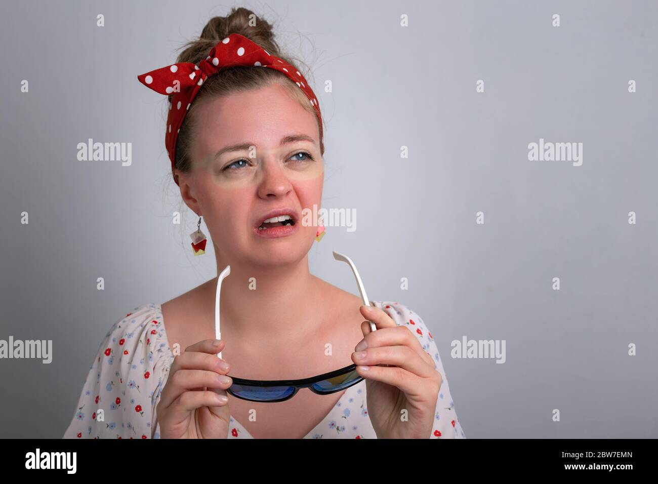 Young caucasian woman girl with red sunglasses sunburn on her face. Stock Photo