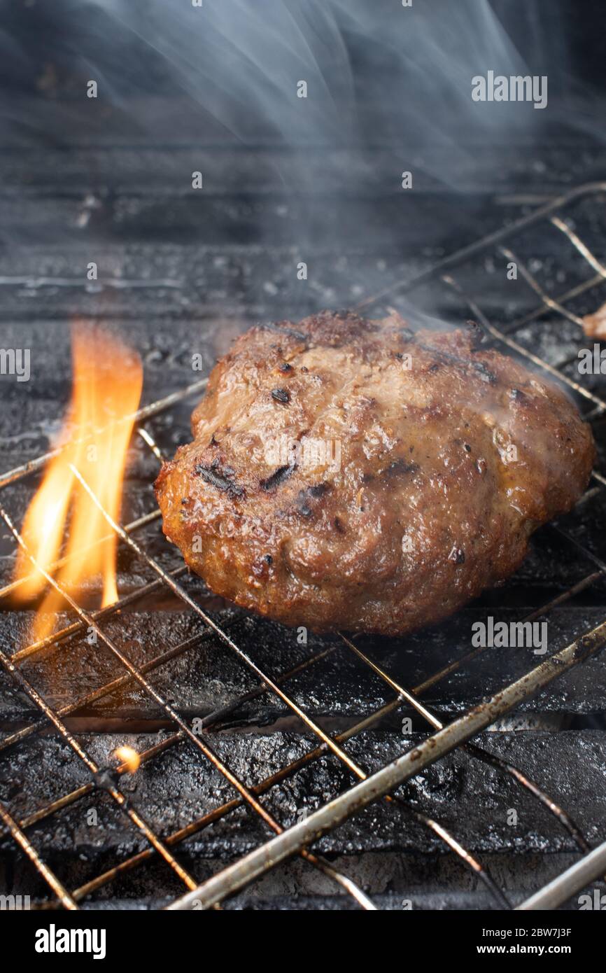 cooking burgers on hot grill with flames Stock Photo Alamy