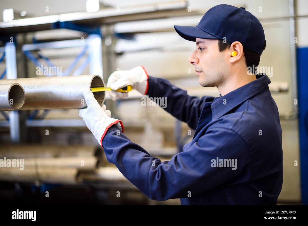 Worker in an industrial plant measuring the size of a pipe Stock Photo ...