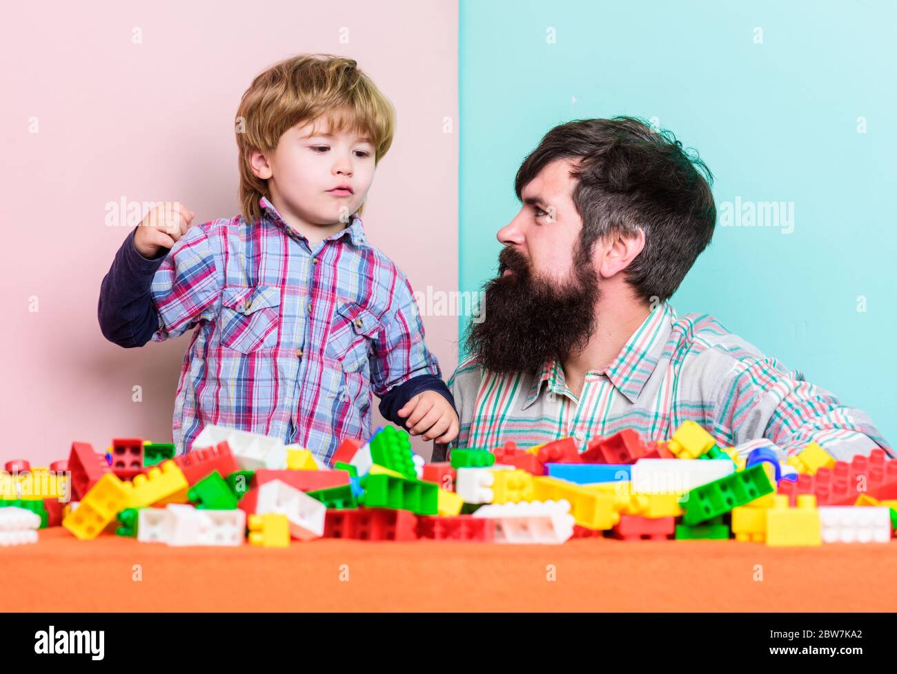 Dad and kid build plastic blocks. Child care development. Family ...