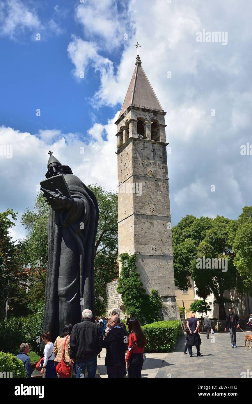 SPLIT, CROATIA - APRIL 29, 2019: Monumental bronze statue of Bishop Gregory of Nin created in 1929 by Ivan Mestrovic and The bell tower and the Chapel Stock Photo