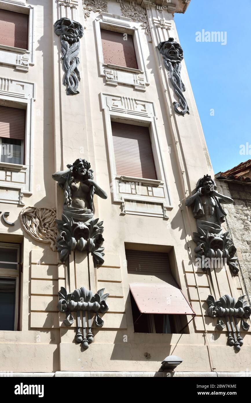 Wall sculptures of human on the one of many historic buildings in old