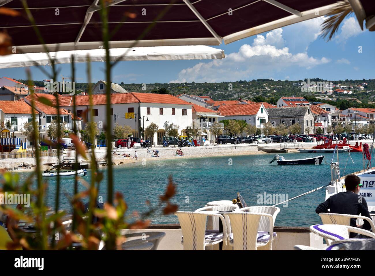 PRIMOSTEN, CROATIA - MAY 2, 2019 - People sitting in cafeteria located in The famous and beautiful Primosten town in Dalmatia - popular tourist destin Stock Photo
