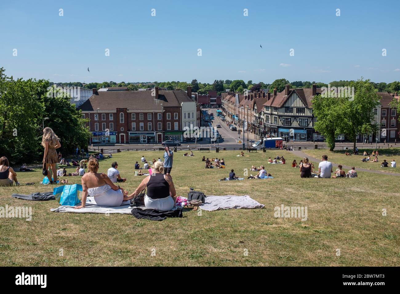 View of people sitting on Windmill Hill overlooking town of Hitchin, Hertfordshire during first few days of lockdown easing during COVID-19 pandemic Stock Photo
