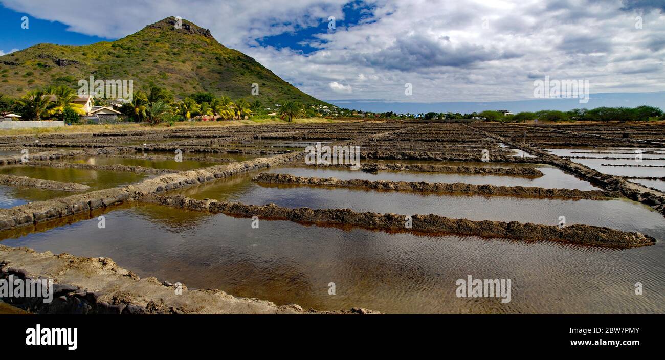 Tamarin Salt Pans is a popular tourist attraction with the square brick clay basins with beautiful mountain in the background. This place produces art Stock Photo