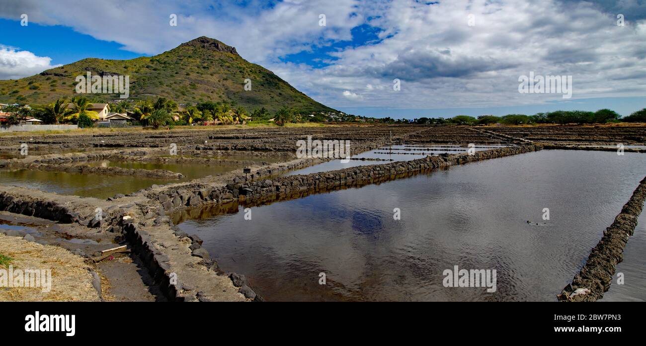 Tamarin Salt Pans is a popular tourist attraction with the square brick clay basins with beautiful mountain in the background. This place produces art Stock Photo