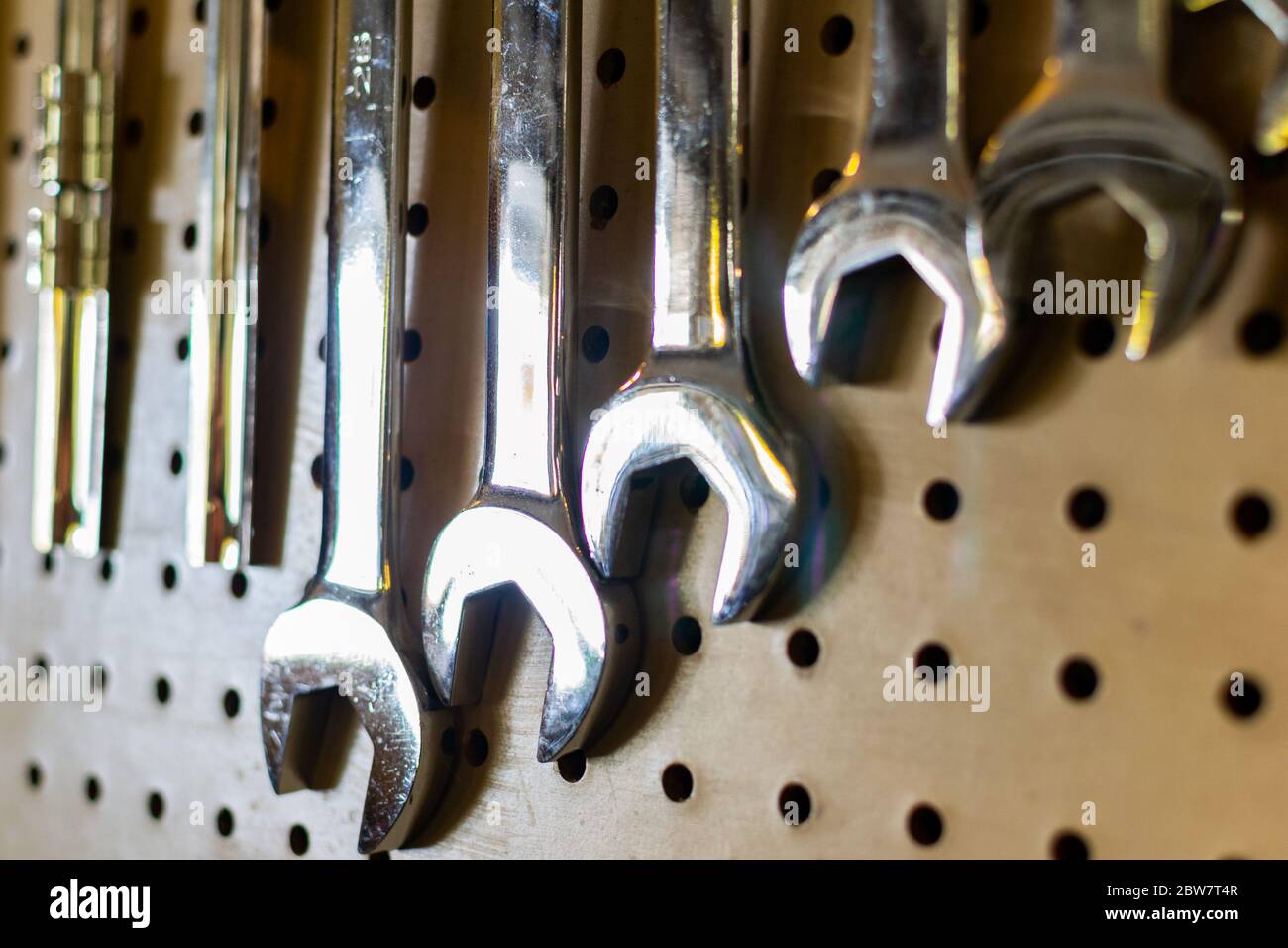 various crescent wrenches hanging from a pegboard in a Stock
