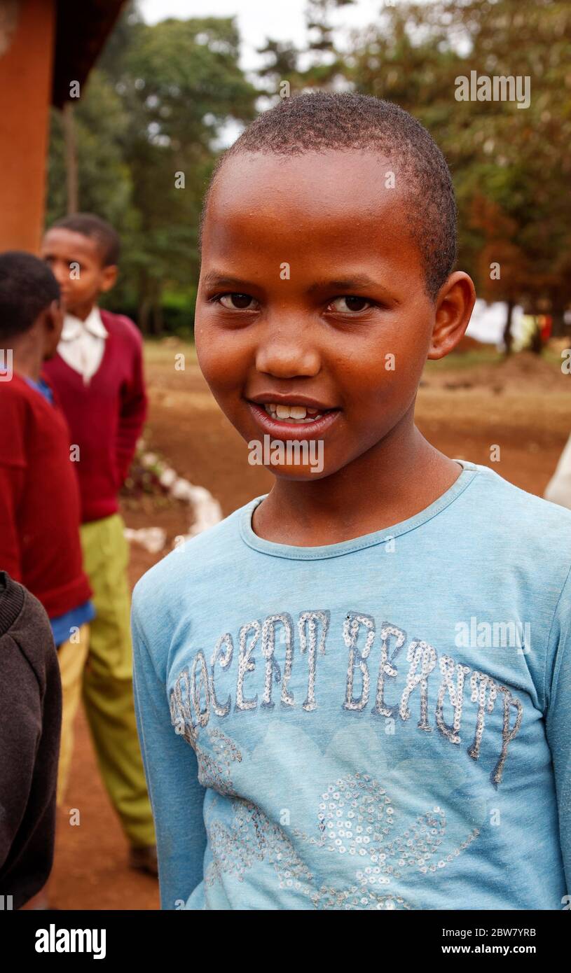 girl, smiling, pretty, blue knit top, close cropped hair, burnished brown skin, Karatu Elementary School, Karatu, Tanzania, Africa Stock Photo