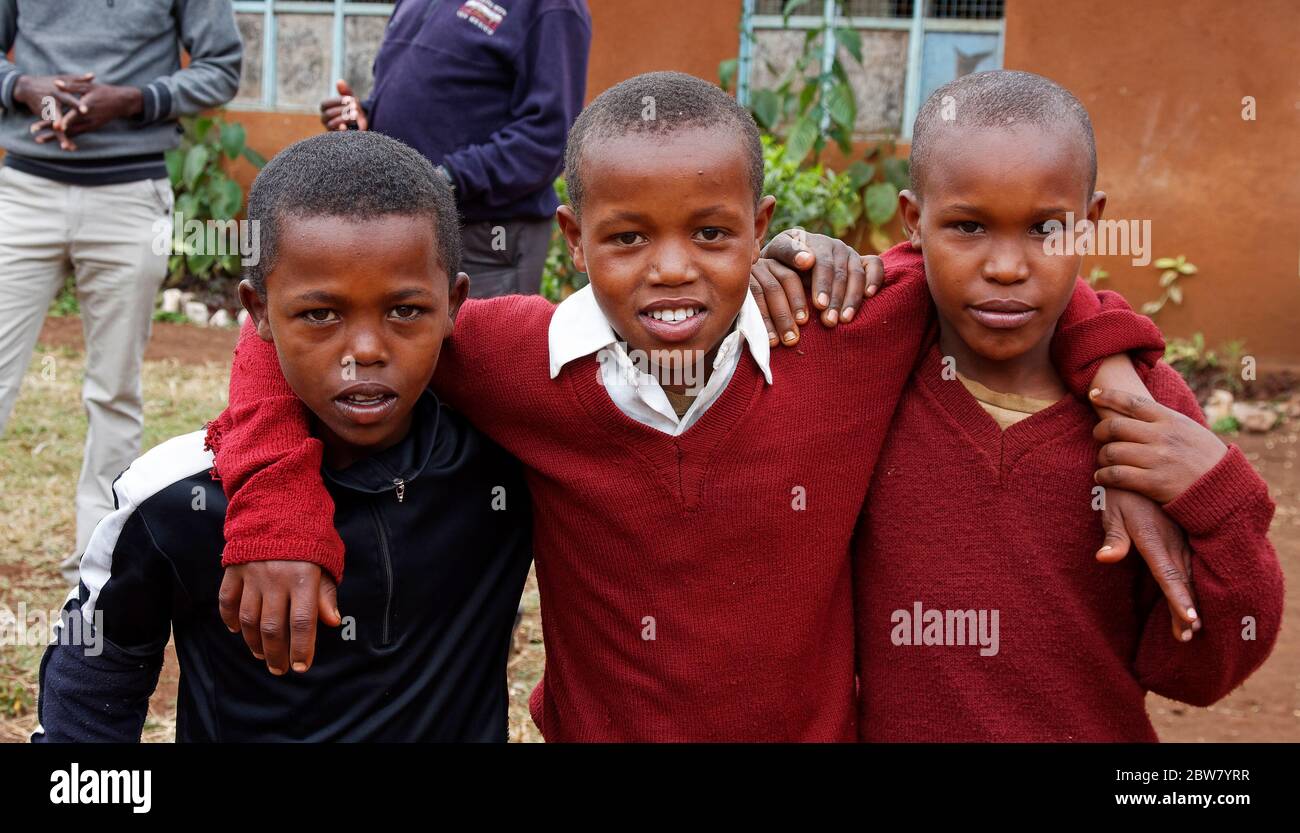 three boys, arms around shoulders, buddies, friends, happy, Karatu Elementary School, Karatu, Tanzania, Africa Stock Photo