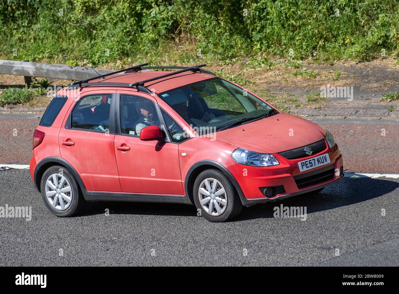 2007 faded paint red Suzuki SX4 GL; Vehicular traffic moving vehicles, cars driving vehicle on UK roads, motors, motoring on the M6 motorway highway Stock Photo