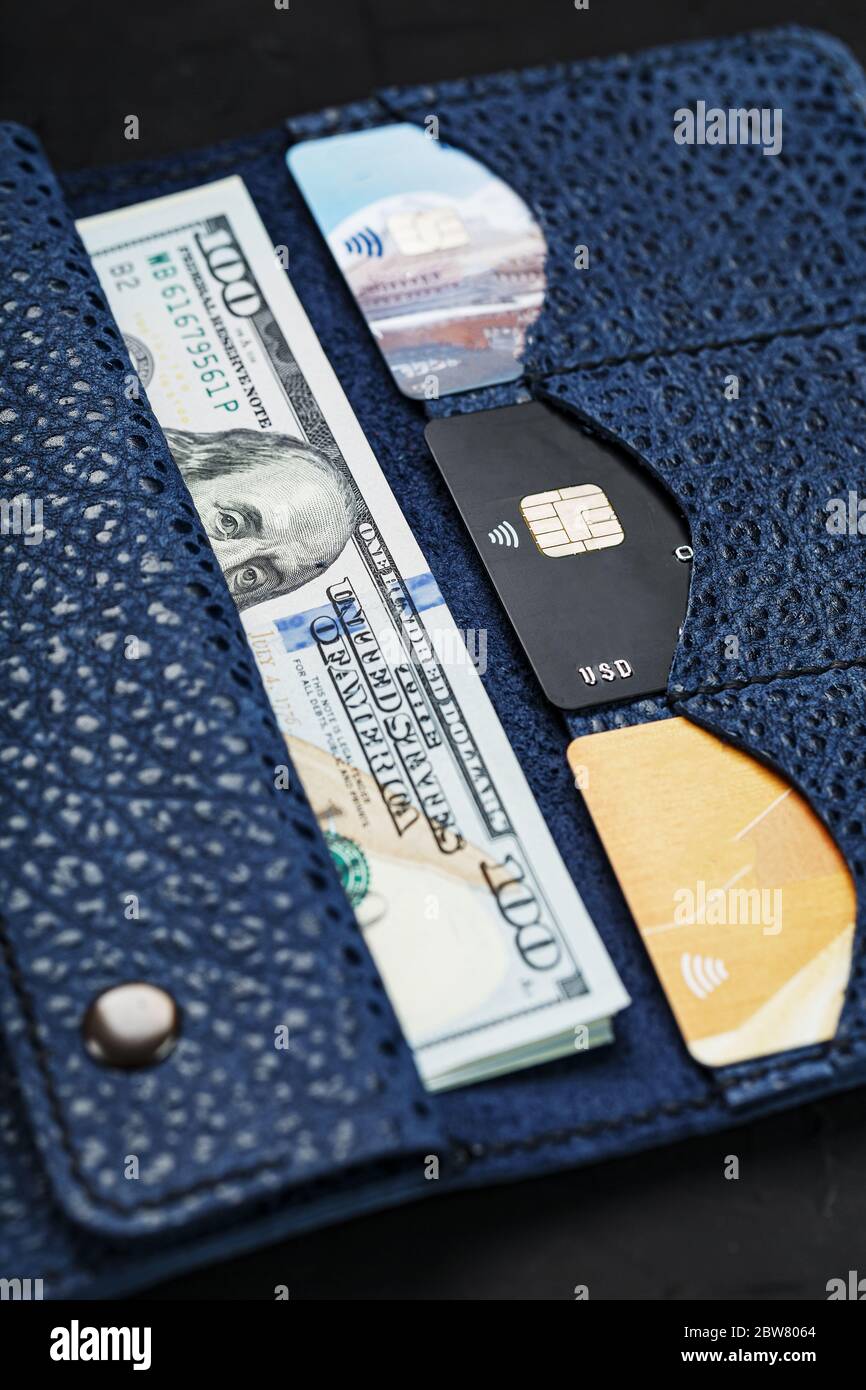 Blue purse with banknotes and credit cards on a black background Stock