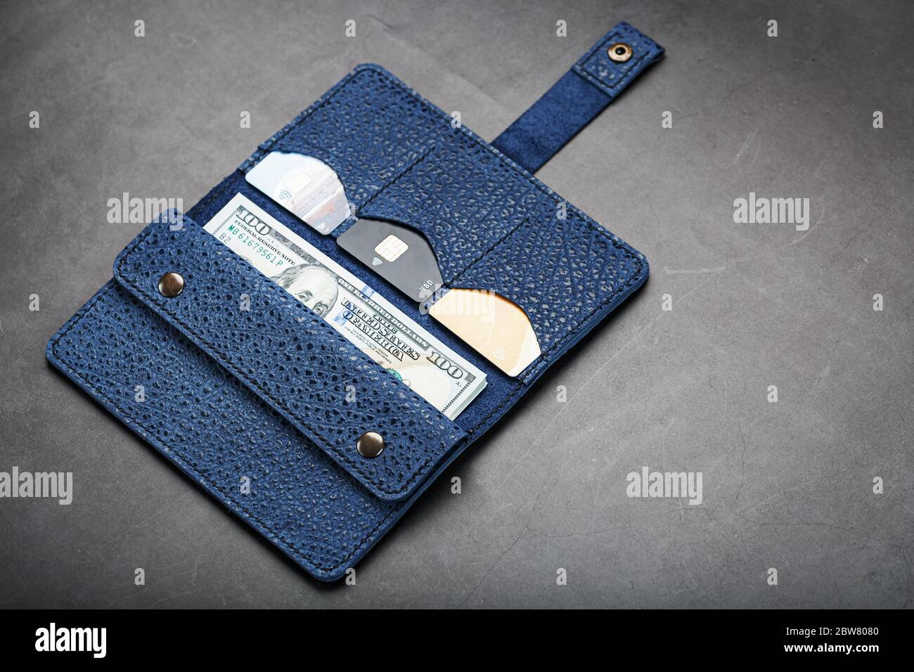 Blue purse with banknotes and credit cards on a black background Stock