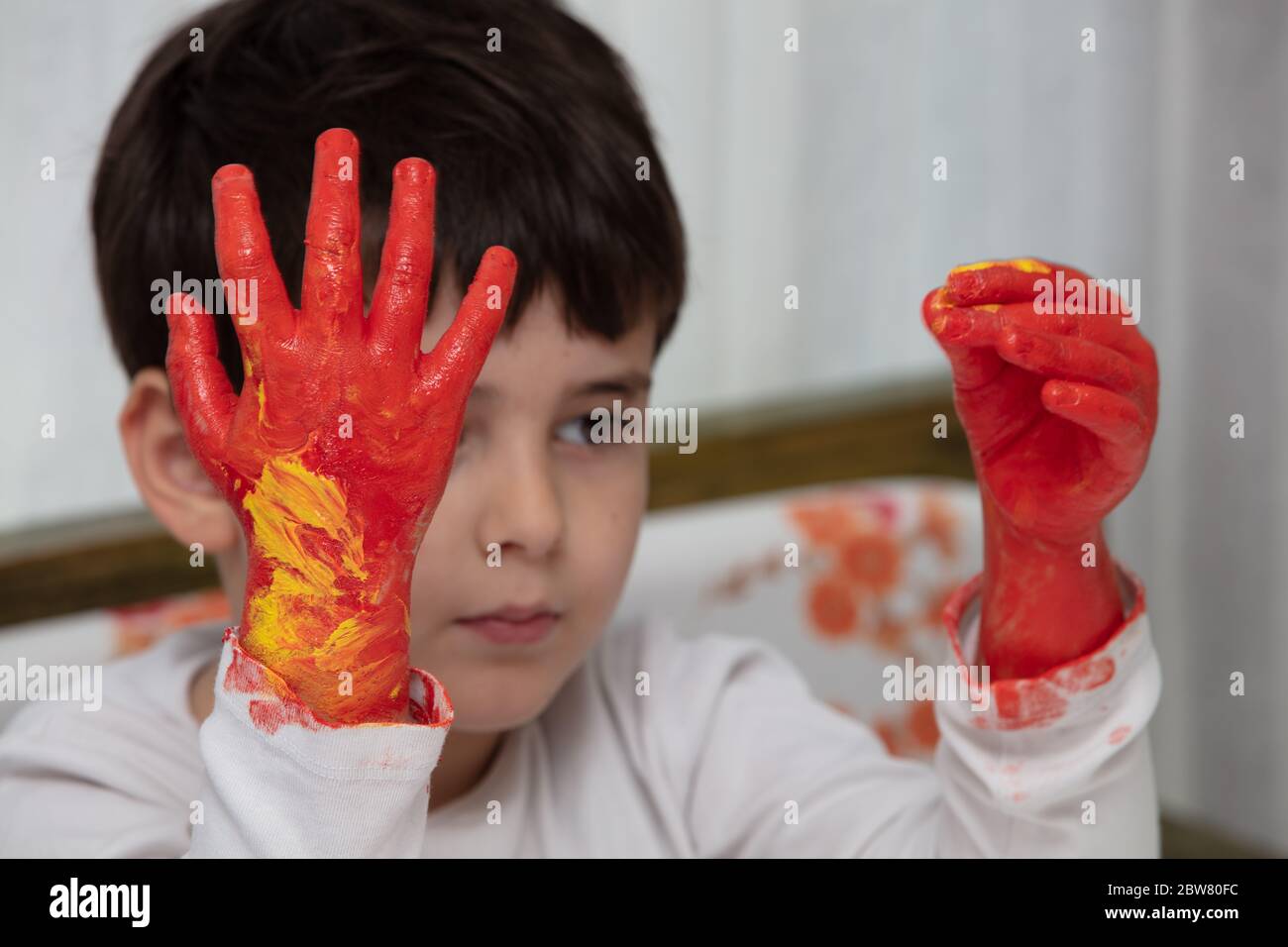 Close up young boy painting with colorful hands. Art, creativity and painting concept Stock Photo