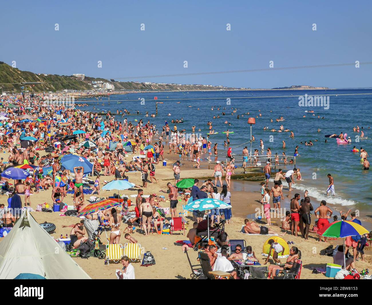 Bournemouth, UK. 30th May 2020. Bournemouth, UK.  Thousands of people descend on Bournemouth beach, many ignoring social distancing rules and crowding the beach and sea. Credit: Thomas Faull/Alamy Live News Stock Photo