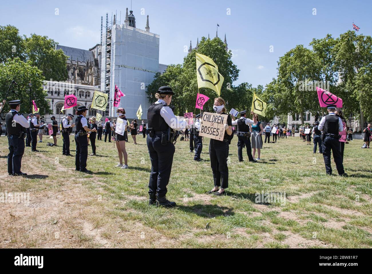 Parliament Square, London, UK. 30 May 2020. A few hundred environmental campaigners from Extinction Rebellion demonstrate peacefully in Parliament Square. Protesters hold placards, demand decisive action from the UK Government on the global environmental crisis. Activists are standing and maintain appropriate social distancing. Police questions individual campaigners prompting them to move on; some are body searched and arrests follow for breach of Covid-19 regulations. Stock Photo