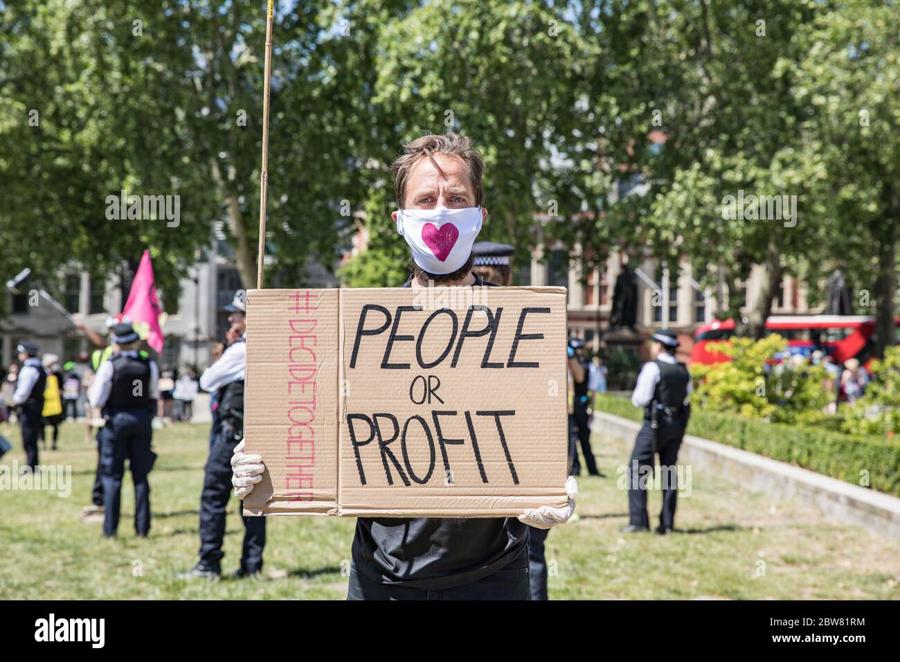 Parliament Square, London, UK. 30 May 2020. A few hundred environmental campaigners from Extinction Rebellion demonstrate peacefully in Parliament Square. Protesters hold placards, demand decisive action from the UK Government on the global environmental crisis. Activists are standing and maintain appropriate social distancing. Police questions individual campaigners prompting them to move on; some are body searched and arrests follow for breach of Covid-19 regulations. Stock Photo