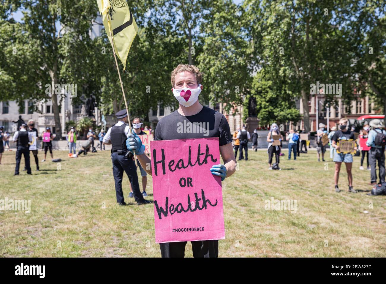 Parliament Square, London, UK. 30 May 2020. A few hundred environmental campaigners from Extinction Rebellion demonstrate peacefully in Parliament Square. Protesters hold placards, demand decisive action from the UK Government on the global environmental crisis. Activists are standing and maintain appropriate social distancing. Police questions individual campaigners prompting them to move on; some are body searched and arrests follow for breach of Covid-19 regulations. Stock Photo