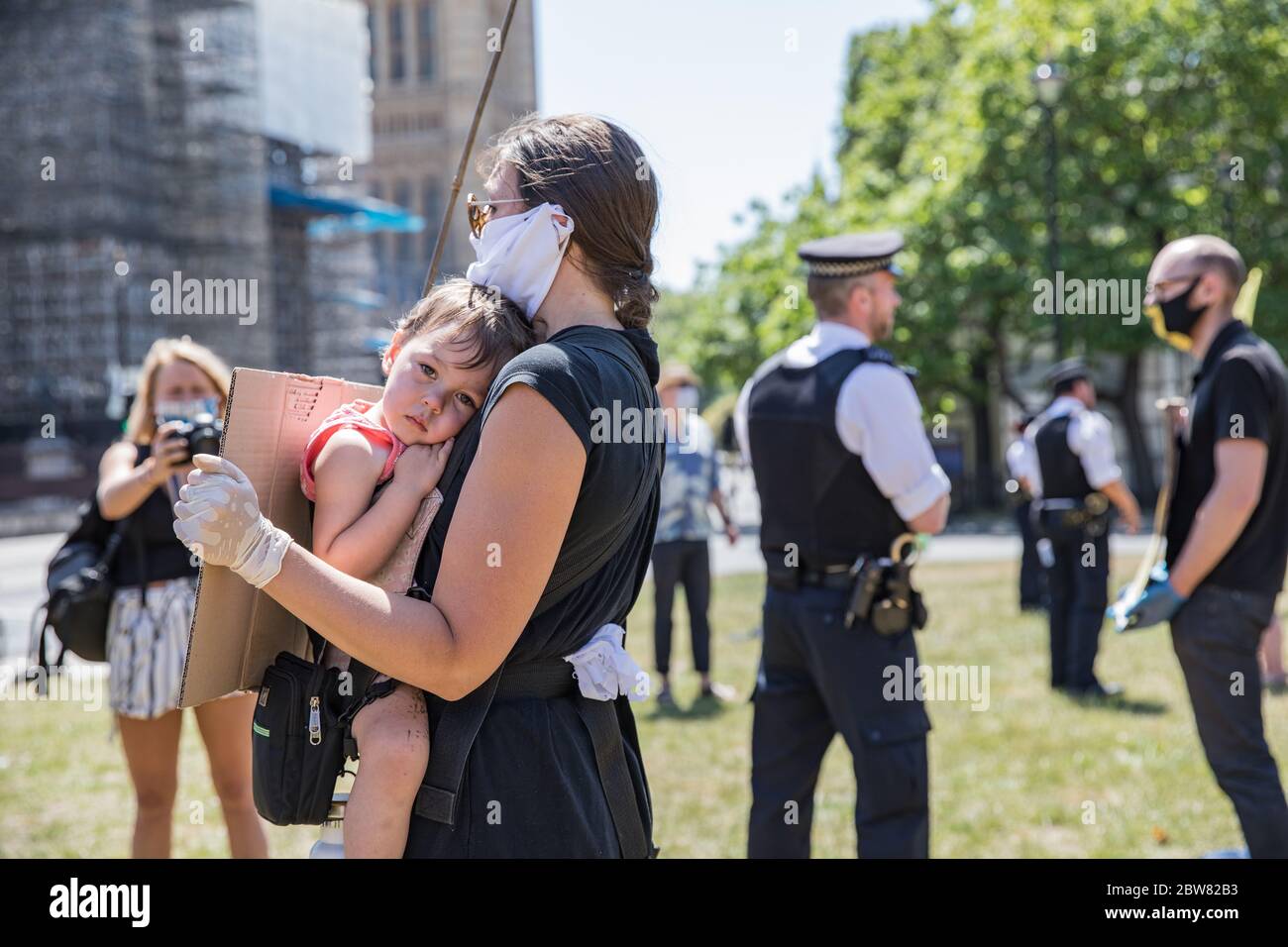 Parliament Square, London, UK. 30 May 2020. A few hundred environmental campaigners from Extinction Rebellion demonstrate peacefully in Parliament Square. Protesters hold placards, demand decisive action from the UK Government on the global environmental crisis. Activists are standing and maintain appropriate social distancing. Police questions individual campaigners prompting them to move on; some are body searched and arrests follow for breach of Covid-19 regulations. Stock Photo