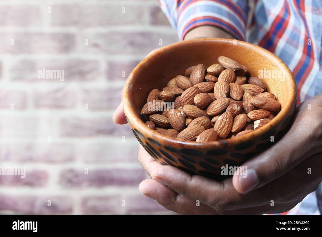 Close up of man hand holding a bowl of almond with copy space Stock Photo
