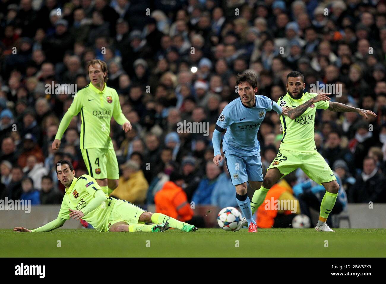 MANCHESTER, ENGLAND - David Silva of Manchester City in action with Ivan Rakitic, Sergio Busquets and Dani Alves da Silva of Barcelona during the UEFA Champions League Round of 16 1st Leg between Manchester City and FC Barcelona at the Etihad Stadium, Manchester on Tuesday 24th February 2015 (Credit: Mark Fletcher | MI News) Stock Photo
