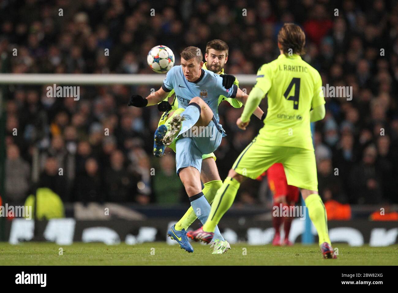 MANCHESTER, ENGLAND - Edin Dzeko of Manchester City battles with Gerard Pique of Barcelona during the UEFA Champions League Round of 16 1st Leg between Manchester City and FC Barcelona at the Etihad Stadium, Manchester on Tuesday 24th February 2015 (Credit: Mark Fletcher | MI News) Stock Photo