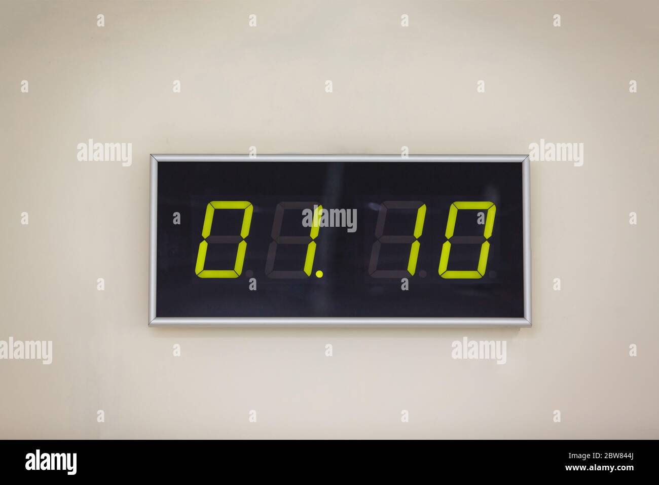Black digital clock on a white background showing time 0110 Stock