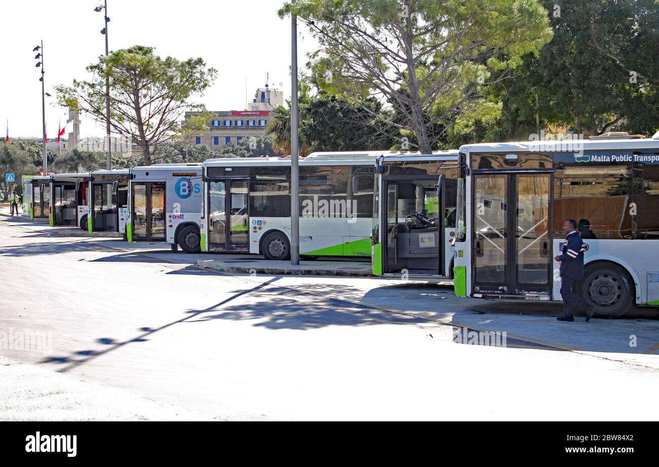 VALLETTA, MALTA- NOVEMBER 10TH 2019: A row of green and white Malta public transport vehicles lined up at Valletta bus terminus Stock Photo