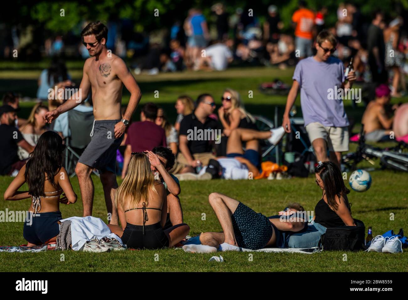 London, UK. 30th May, 2020. Large groups of people (against both current and future guidance) enjoy the sun on Clapham Common after the Government eased restrictions and allowed people to meet - Lambeth Council have replaced signs to say stay alert and to allow people sit on benches. The eased 'lockdown' continues for the Coronavirus (Covid 19) outbreak in London. Credit: Guy Bell/Alamy Live News Stock Photo