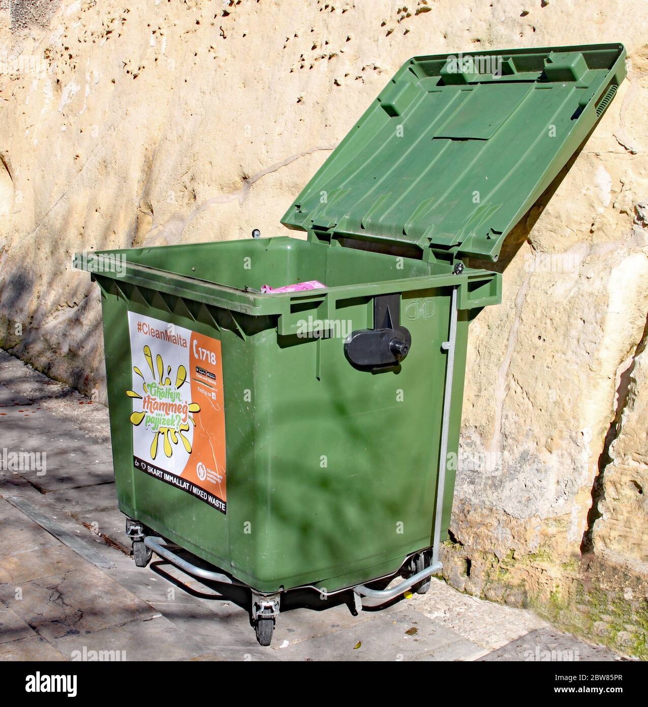 VALLETTA, MALTA - NOVEMBER 10TH 2019: A green rubbish bin stands open near the Valletta bus station. Ghalfejn thammeg pajjizek means Why tarnish your Stock Photo