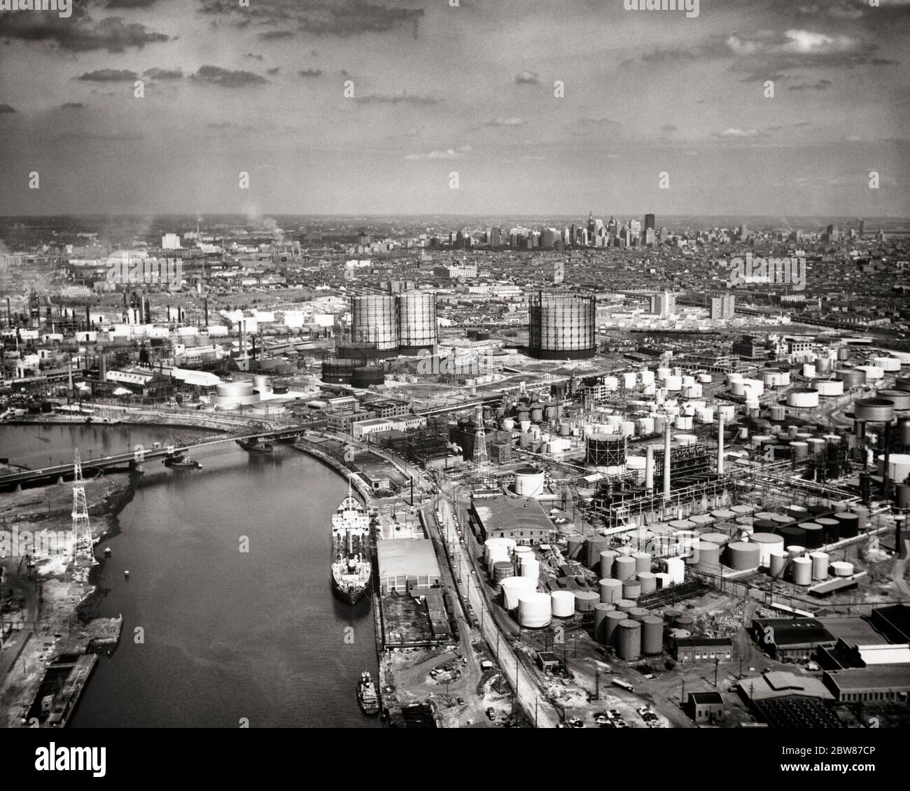 1950s SKYLINE AERIAL VIEW OF OIL REFINERIES ALONG SCHUYLKILL RIVER CENTER CITY PHILADELPHIA IN BACKGROUND PENNSYLVANIA USA - a868 HAR001 HARS OLD FASHIONED Stock Photo