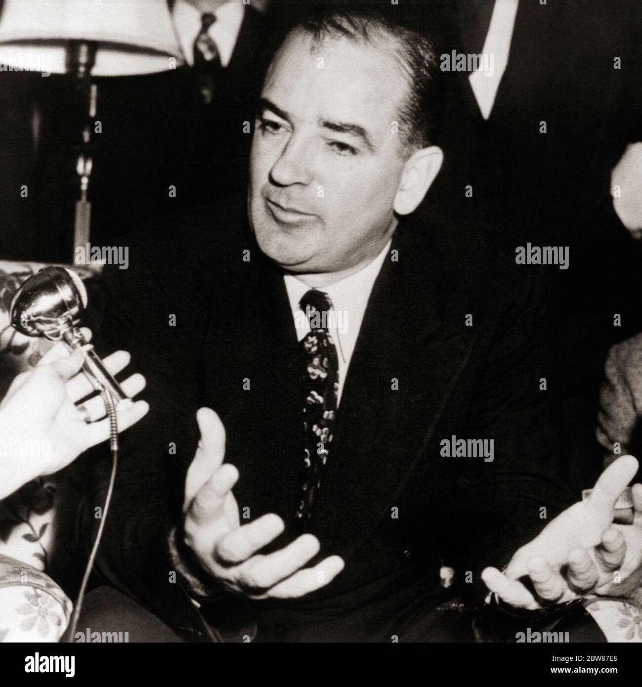 1950s 1954 WISCONSIN SENATOR JOSEPH RAYMOND McCARTHY  SPEAKING INTO MICROPHONE DURING ARMY-McCARTHY HEARINGS WASHINGTON DC USA  - asp fwp3045 ASP001 HARS POWERFUL JOSEPH FALSE INTO OF OCCUPATIONS POLITICS CAMPAIGN CONCEPTUAL LIAR MID-ADULT MID-ADULT MAN WI 1954 BLACK AND WHITE CAUCASIAN ETHNICITY COMMUNISM DURING OLD FASHIONED SENATOR TACTICS Stock Photo